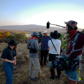 Directors Efraín and Rebecca, DP Eber and soundperson Toto conduct interview at sunset in hills over Penjamillo.