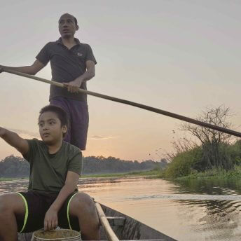 Sidhanta and son Betly on a boat in the village wetland