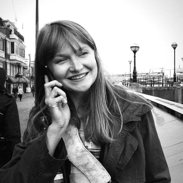 Portrait of director Maris Salumets while talking on a cellphone.