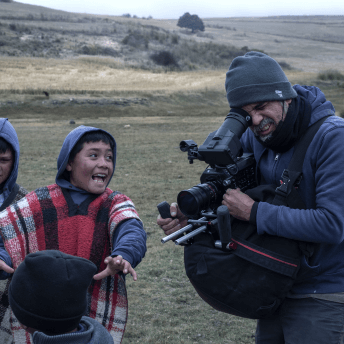 A cameraman films children as they laugh together.